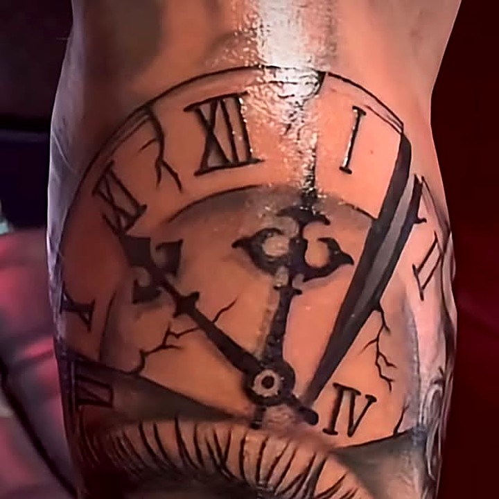 Black and grey clock tattoo with Roman numerals